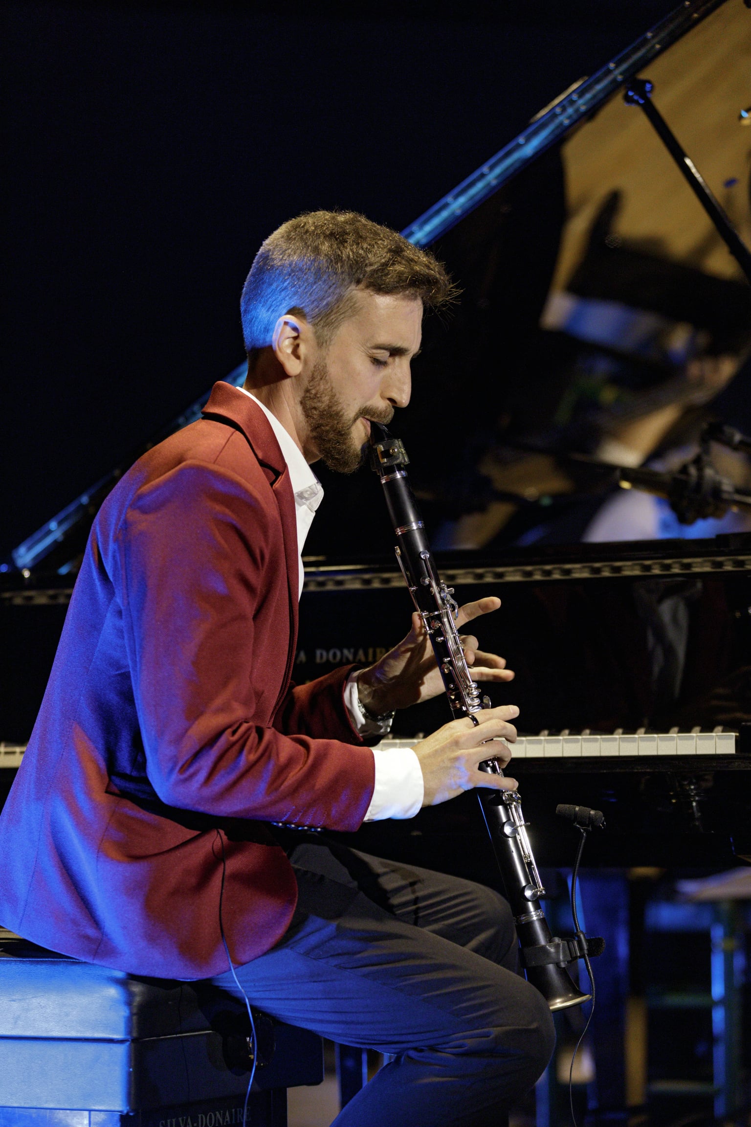 Josemi Castaño tocando el clarinete con el piano de fondo