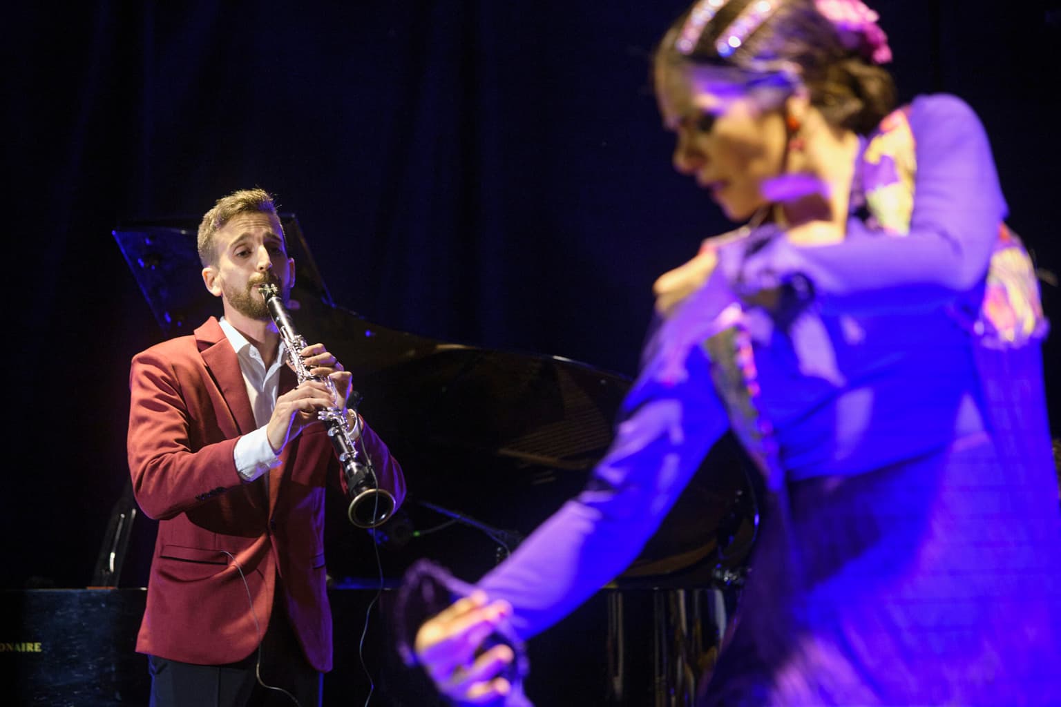 Josemi Castaño tocando el clarinete con fondo azul del escenario